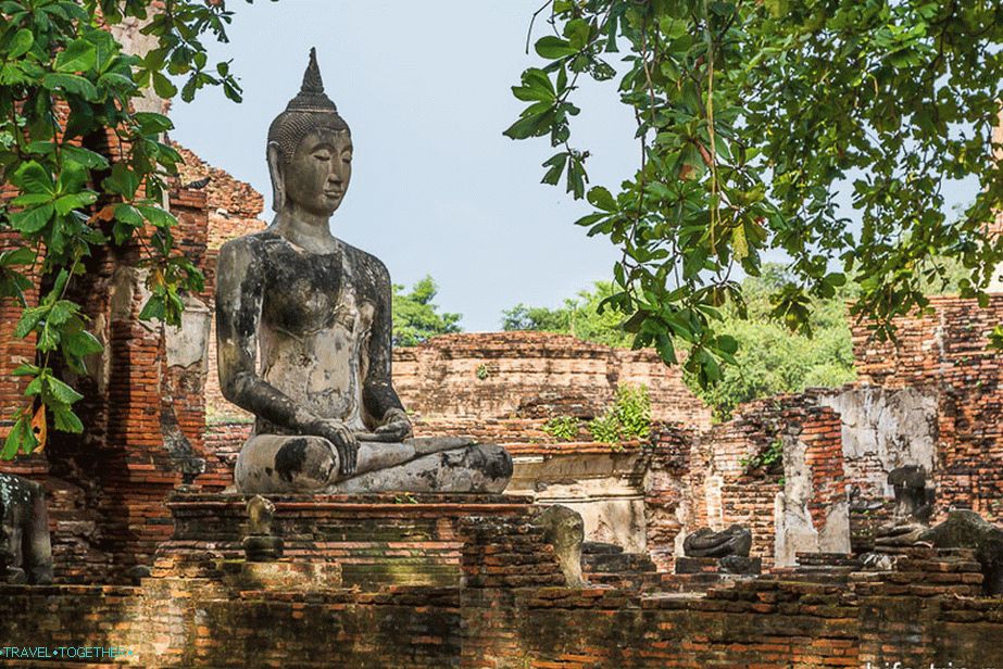Buddha medzi zrúcaninou a stromami