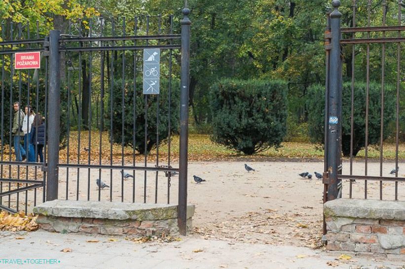 Jeden z vchodov do Лазazienki, vidíme zákaz cyklistiky, skútre a psy